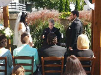 bride and groom with officiant and wedding guests